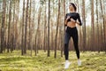 Pretty young girl runner in the forest. Healthy lifestyle content. Royalty Free Stock Photo