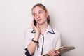 Pretty young girl secretary. Girl holds documents and talks on the phone