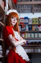 Pretty young girl servant costume portrait dressed in red in the shop Royalty Free Stock Photo