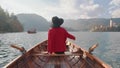 Pretty young girl sitting in boat and looking for the inspiration at background of the Alph mountain. Happy asian woman