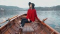 Pretty young girl sitting in boat and looking for the inspiration at background of the Alph mountain view. Happy asian