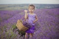 Pretty young girl sitting in lavender field in nice hat boater with purple flower on it. Royalty Free Stock Photo