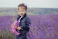 Pretty young girl sitting in lavender field in nice hat boater with purple flower on it. Royalty Free Stock Photo