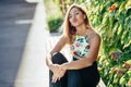 Pretty young girl sitting on urban bench blowing a kiss Royalty Free Stock Photo