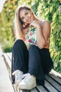 Pretty young girl sitting on urban bench