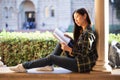 Pretty young girl sitting on the window at the university terrace with a book in her hands Royalty Free Stock Photo