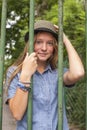 pretty young girl standing behind bars in the city Park. Royalty Free Stock Photo