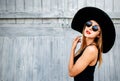 Pretty young girl standing near wooden wall in black swimwear Royalty Free Stock Photo