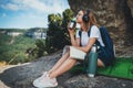 Pretty young girl traveling sitting in mountains drinking tea from camping thermos enjoying trip, tourist student is relaxing Royalty Free Stock Photo