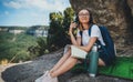 Pretty young girl traveling sitting in mountains planning route on map and drinking tea from camping thermos enjoying the trip Royalty Free Stock Photo