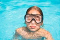 Pretty young girl in the water, portrait of kid with diving mask in swimming pool Royalty Free Stock Photo