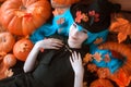 Pretty young girl witch halloween costume dressed in black with pumpkins Royalty Free Stock Photo