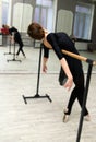 Pretty young graceful ballet dancer warms up in ballet class