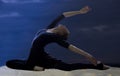 Pretty young graceful ballet dancer warms up on a sandy beach Royalty Free Stock Photo