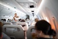 Pretty, young happy woman aboard an airplane during a lang haul commercial flight