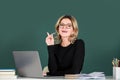 Pretty young high school or college teacher on the chalkboard. Young caucasian female teacher portrait with pointing Royalty Free Stock Photo