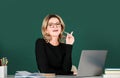 Pretty young high school or college teacher on the chalkboard. Young caucasian female teacher portrait with pointing Royalty Free Stock Photo