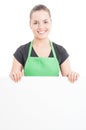 Pretty young hypermarket employee holding empty paper billboard