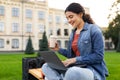 Pretty young indian woman sitting on bench, studying, using laptop Royalty Free Stock Photo