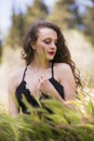 Pretty young lady among large weeds field Royalty Free Stock Photo