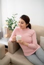 Pretty young lady relaxing with tea cup at living room Royalty Free Stock Photo