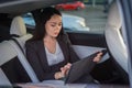 Young businesswoman using digital tablet while sitting in the back seat of a car. Copy space. Business, road trip