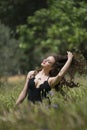 Pretty young lady among large weeds field Royalty Free Stock Photo