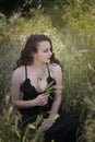 Pretty young lady among large weeds field Royalty Free Stock Photo