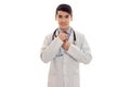 Pretty young man doctor in uniform with stethoscop on his neck looking and posing and smiling on camera isolated on Royalty Free Stock Photo