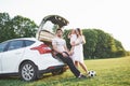 Pretty young married couple and their daughter are resting in the nature. The mother father and little girl are sitting Royalty Free Stock Photo