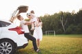 Pretty young married couple and their daughter are resting in the nature. The mother father and little girl are sitting Royalty Free Stock Photo