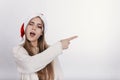 Pretty young model in santa claus hat pointing something Royalty Free Stock Photo