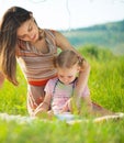 Pretty young mother reading book to her little daughter Royalty Free Stock Photo