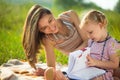 Pretty young mother reading book to her little daughter Royalty Free Stock Photo