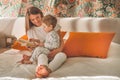 Pretty young mother reading a book to her little son in modern interior Royalty Free Stock Photo