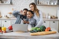 Pretty young mother and two children sons preparing salad with fresh vegetables Royalty Free Stock Photo