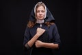 Pretty young nun in religion concept against dark background. Royalty Free Stock Photo