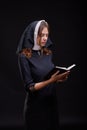 Pretty young nun in religion concept against dark background. Royalty Free Stock Photo