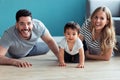 Pretty young parents looking at camera while playing with baby son at home Royalty Free Stock Photo