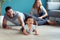 Pretty young parents playing with baby son while sitting on the floor at home Royalty Free Stock Photo