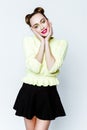 Pretty young playful girl dressed in green pullover and black skirt. Royalty Free Stock Photo