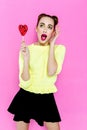 Pretty young playful girl holding heart-shaped lollipop Royalty Free Stock Photo