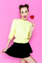 Pretty young playful girl holding heart-shaped lollipop Royalty Free Stock Photo