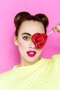 Pretty young playful girl holding heart-shaped lollipop Royalty Free Stock Photo