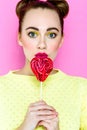 Pretty young playful girl holding heart-shaped lollipop Royalty Free Stock Photo