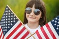 Pretty young pre-teen girl in field holding American flag Royalty Free Stock Photo