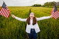 Pretty young pre-teen girl in field holding American flag Royalty Free Stock Photo