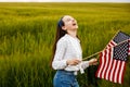 Pretty young pre-teen girl in field holding American flag Royalty Free Stock Photo