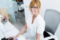 Pretty young receptionist looking at camera and smiling in the reception of clinic. Royalty Free Stock Photo