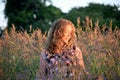 Pretty Young Redhead Female Enjoying the Golden Evening Sun While Sitting Amoungst the Wildflowers in the Meadow Royalty Free Stock Photo